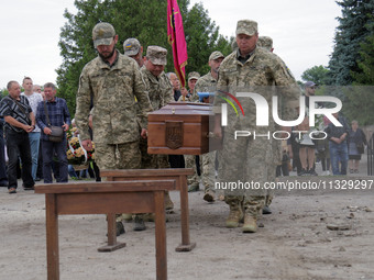 Soldiers are carrying the coffin of Ukrainian serviceman, artist, musician, stylist, and queer community member Artur Snitkus, 36, who peris...