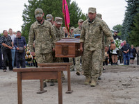 Soldiers are carrying the coffin of Ukrainian serviceman, artist, musician, stylist, and queer community member Artur Snitkus, 36, who peris...