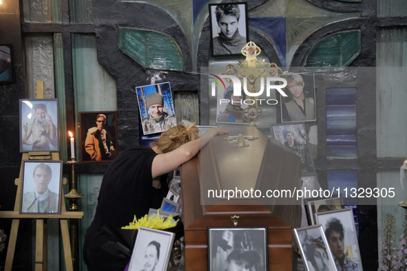 A woman is grieving by the coffin of Ukrainian serviceman, artist, musician, stylist, and queer community member Artur Snitkus, 36, who peri...