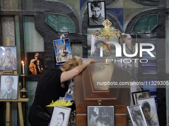 A woman is grieving by the coffin of Ukrainian serviceman, artist, musician, stylist, and queer community member Artur Snitkus, 36, who peri...