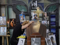 A woman is grieving by the coffin of Ukrainian serviceman, artist, musician, stylist, and queer community member Artur Snitkus, 36, who peri...