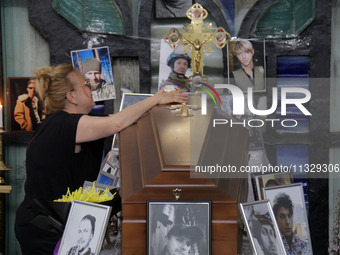 A woman is grieving by the coffin of Ukrainian serviceman, artist, musician, stylist, and queer community member Artur Snitkus, 36, who peri...