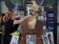 A woman is grieving by the coffin of Ukrainian serviceman, artist, musician, stylist, and queer community member Artur Snitkus, 36, who peri...