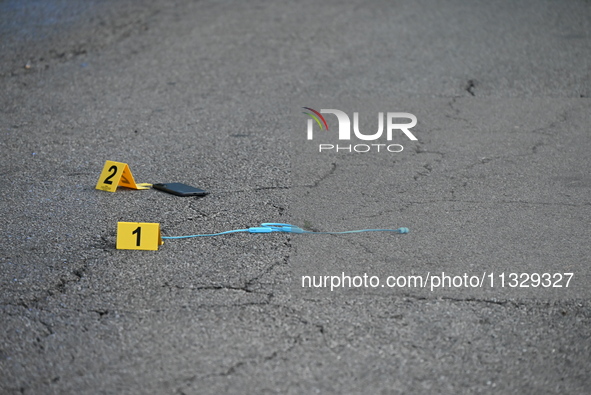 Evidence markers are showing a USB charger and a phone on the ground at the mass shooting crime scene. Four people are being shot in a mass...