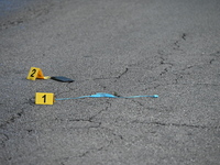 Evidence markers are showing a USB charger and a phone on the ground at the mass shooting crime scene. Four people are being shot in a mass...