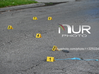 Evidence markers on the ground are showing where a cell phone, USB charger, and shell casings are at the scene of an early morning mass shoo...