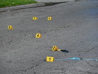 Evidence markers on the ground are showing where a cell phone, USB charger, and shell casings are at the scene of an early morning mass shoo...