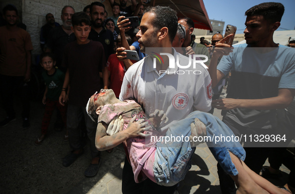 An injured girl is being brought to the al-Aqsa Martyrs Hospital in Deir al-Balah, in the central Gaza Strip, following the Israeli bombardm...