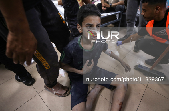 An injured boy is being brought to the al-Aqsa Martyrs Hospital in Deir al-Balah, in the central Gaza Strip, on June 14, 2024, following the...