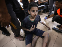 An injured boy is being brought to the al-Aqsa Martyrs Hospital in Deir al-Balah, in the central Gaza Strip, on June 14, 2024, following the...