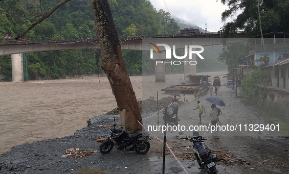 Villagers are walking on the roads adjacent to the Teesta River, where water is entering the roads near their houses due to the risen water...