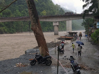 Villagers are walking on the roads adjacent to the Teesta River, where water is entering the roads near their houses due to the risen water...