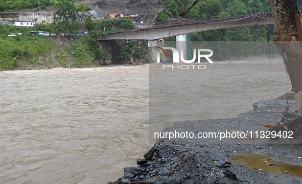 A motorbike is being seen near the riverbed as the waters of the Teesta River are entering the roads near houses due to the risen water leve...