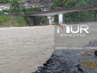 A motorbike is being seen near the riverbed as the waters of the Teesta River are entering the roads near houses due to the risen water leve...