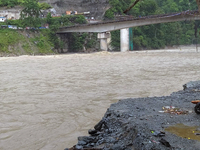 A motorbike is being seen near the riverbed as the waters of the Teesta River are entering the roads near houses due to the risen water leve...