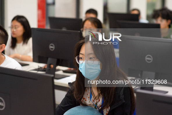 A marking teacher is carefully evaluating a college entrance examination paper at a marking point at a college in Nanjing, China, on June 14...