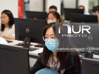 A marking teacher is carefully evaluating a college entrance examination paper at a marking point at a college in Nanjing, China, on June 14...