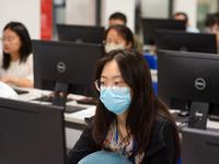 A marking teacher is carefully evaluating a college entrance examination paper at a marking point at a college in Nanjing, China, on June 14...