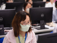 A marking teacher is carefully evaluating a college entrance examination paper at a marking point at a college in Nanjing, China, on June 14...