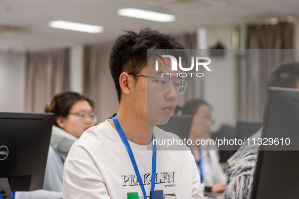 A marking teacher is carefully evaluating a college entrance examination paper at a marking point at a college in Nanjing, China, on June 14...