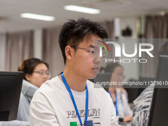 A marking teacher is carefully evaluating a college entrance examination paper at a marking point at a college in Nanjing, China, on June 14...