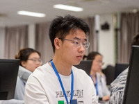 A marking teacher is carefully evaluating a college entrance examination paper at a marking point at a college in Nanjing, China, on June 14...