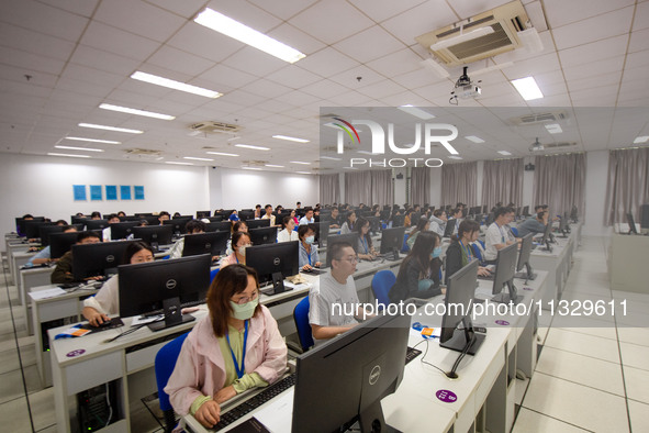 A marking teacher is carefully evaluating a college entrance examination paper at a marking point at a college in Nanjing, China, on June 14...