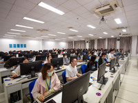 A marking teacher is carefully evaluating a college entrance examination paper at a marking point at a college in Nanjing, China, on June 14...