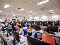 A marking teacher is carefully evaluating a college entrance examination paper at a marking point at a college in Nanjing, China, on June 14...