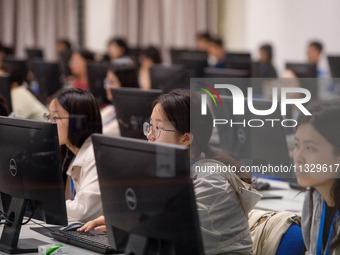 A marking teacher is carefully evaluating a college entrance examination paper at a marking point at a college in Nanjing, China, on June 14...