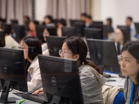 A marking teacher is carefully evaluating a college entrance examination paper at a marking point at a college in Nanjing, China, on June 14...