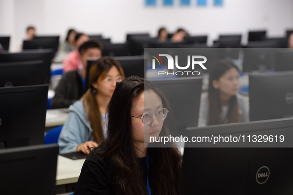 A marking teacher is carefully evaluating a college entrance examination paper at a marking point at a college in Nanjing, China, on June 14...