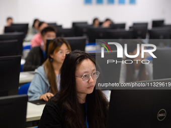 A marking teacher is carefully evaluating a college entrance examination paper at a marking point at a college in Nanjing, China, on June 14...