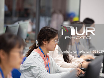 A marking teacher is carefully evaluating a college entrance examination paper at a marking point at a college in Nanjing, China, on June 14...