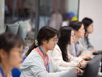 A marking teacher is carefully evaluating a college entrance examination paper at a marking point at a college in Nanjing, China, on June 14...