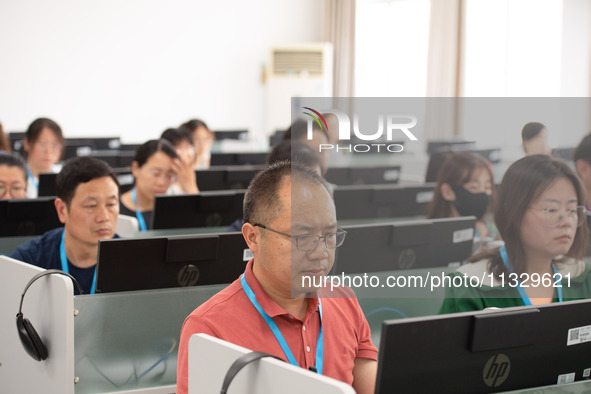 A marking teacher is carefully evaluating a college entrance examination paper at a marking point at a college in Nanjing, China, on June 14...