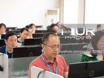 A marking teacher is carefully evaluating a college entrance examination paper at a marking point at a college in Nanjing, China, on June 14...