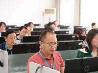 A marking teacher is carefully evaluating a college entrance examination paper at a marking point at a college in Nanjing, China, on June 14...