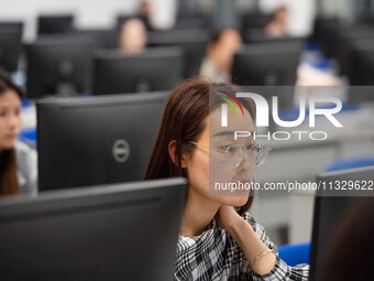 A marking teacher is carefully evaluating a college entrance examination paper at a marking point at a college in Nanjing, China, on June 14...