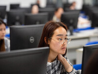 A marking teacher is carefully evaluating a college entrance examination paper at a marking point at a college in Nanjing, China, on June 14...