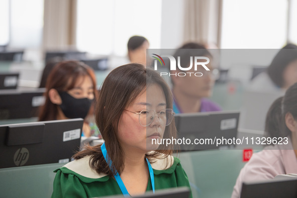 A marking teacher is carefully evaluating a college entrance examination paper at a marking point at a college in Nanjing, China, on June 14...