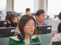 A marking teacher is carefully evaluating a college entrance examination paper at a marking point at a college in Nanjing, China, on June 14...