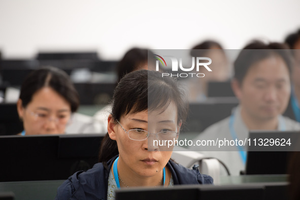 A marking teacher is carefully evaluating a college entrance examination paper at a marking point at a college in Nanjing, China, on June 14...