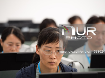 A marking teacher is carefully evaluating a college entrance examination paper at a marking point at a college in Nanjing, China, on June 14...