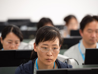 A marking teacher is carefully evaluating a college entrance examination paper at a marking point at a college in Nanjing, China, on June 14...