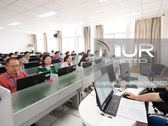 A marking teacher is carefully evaluating a college entrance examination paper at a marking point at a college in Nanjing, China, on June 14...