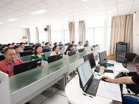 A marking teacher is carefully evaluating a college entrance examination paper at a marking point at a college in Nanjing, China, on June 14...