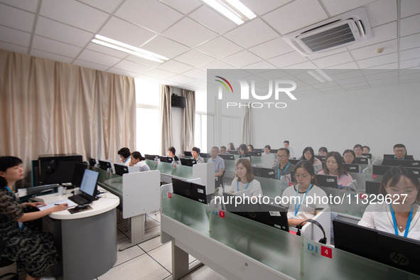 A marking teacher is carefully evaluating a college entrance examination paper at a marking point at a college in Nanjing, China, on June 14...