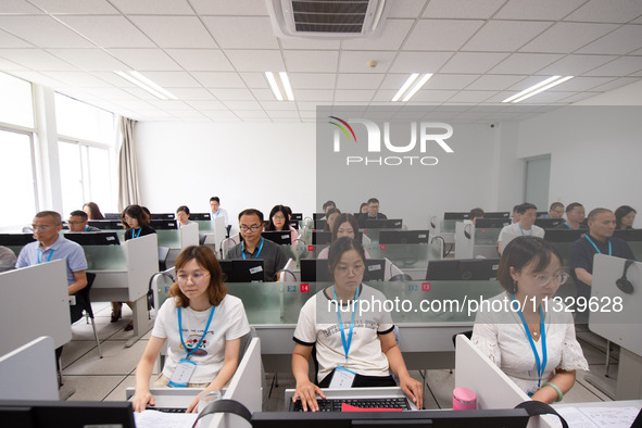 A marking teacher is carefully evaluating a college entrance examination paper at a marking point at a college in Nanjing, China, on June 14...