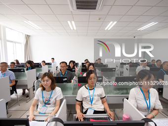 A marking teacher is carefully evaluating a college entrance examination paper at a marking point at a college in Nanjing, China, on June 14...